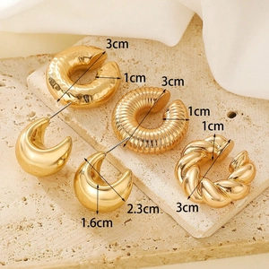 Detailed view of five textured gold hoop earrings with size measurements on stone background