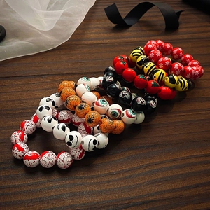 Gros plan de perles en bois d'Halloween avec motifs de crânes et citrouilles sur bracelets