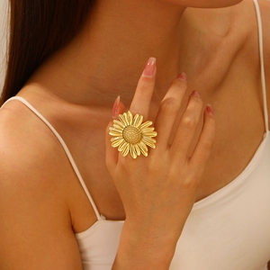 Makroaufnahme eines 18K vergoldeten Sonnenblumenrings mit feinen Blütenblatt-Texturen am Finger