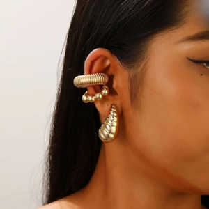 Detailed view of gold plated clip-on earrings set with hollow oval and textured drops