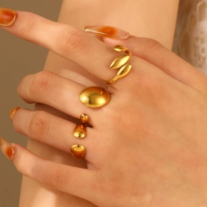 Detaillierte Nahaufnahme von drei 18K vergoldeten geometrischen Ringen an einer Hand