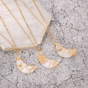 Collares de media luna de alambre dorado con colgantes de nácar blanco en mármol