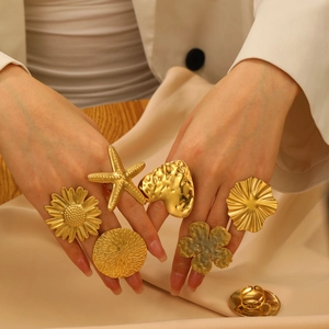 6er-Set goldene Statement-Ringe mit Sonnenblumen- und Seestern-Design auf Seidenhintergrund
