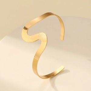 Polished golden irregular S-shaped open wave cuff bracelet for women on display stand