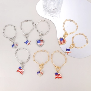 Detail showing heart and star charms with US flag patterns on gold and silver bracelets