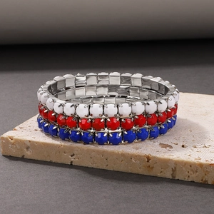 Detailed macro view of three elastic beaded bracelets with red, white and blue faceted beads