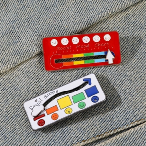 Close-up of interactive social mood and social battery enamel pins on blue denim fabric