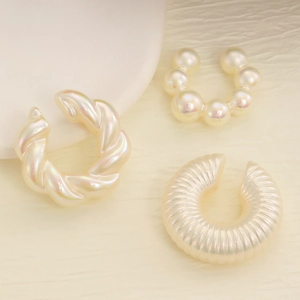 Three-piece set of cream white textured ear cuffs with pearl and twisted stripe designs