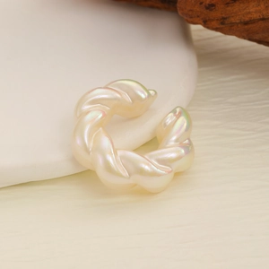 Close-up of twisted rope clip earrings with iridescent ivory white faux pearl finish
