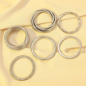 Detail of multi-layered elastic metal bracelets in silver and gold spring design