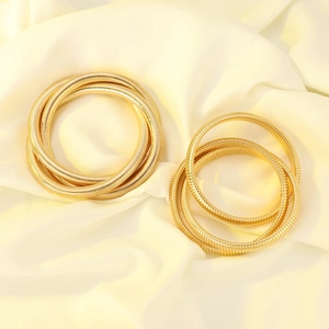 Detail shot of multi-layer golden snake chain stretch bracelet on elegant silk