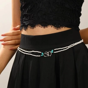 Detail van de dubbellaagse kralen taailleketting met turquoise accenten en hartsluiting