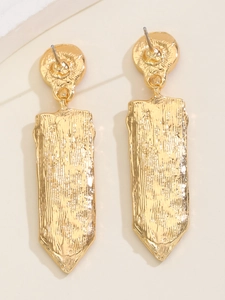 Details von langen goldenen Ohrhängern mit strukturierter Baumrinden-Optik auf der Oberfläche