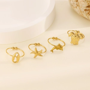 Set of four gold ocean rings featuring starfish, turtle, dolphin and conch charms