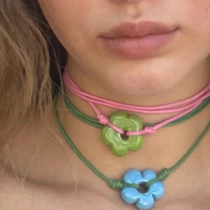 Nahaufnahme der böhmischen Blumen-Halskette mit grünem Anhänger und Kordel-Detail
