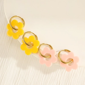 Details von Acryl-Blütenanhängern an goldenen Creolen in den Farben Gelb und Rosa