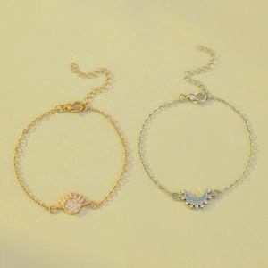 Gedetailleerde close-up van gouden zon en zilveren maan hangers op fijne armbanden