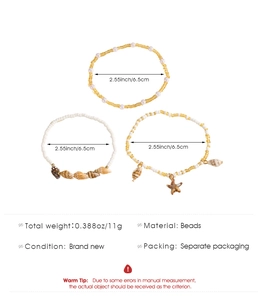 Detalle de la tobillera bohemia de varias capas con dijes de estrella de mar y concha