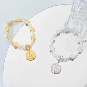 Détail des médailles de Saint-Benoît et bracelets en perles en finitions or et argent