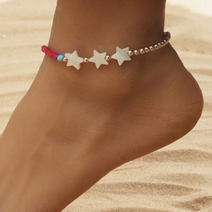 Détail de la chevillère bohème à plusieurs rangs avec étoiles sur une plage