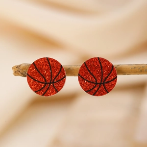 Detailansicht von Basketball-Ohrsteckern mit orangefarbenem Glitzer auf einem Holzzweig