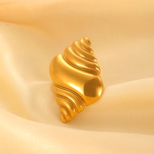 Detailed view of polished gold conch sea shell open ring on champagne silk background
