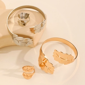Detailed view of adjustable leaf pattern open bracelets and rings in gold and silver finish