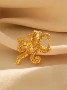 Macro shot of octopus-shaped adjustable gold ring showing detailed metallic texture