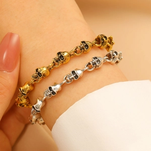 Dettaglio macro di bracciali teschio gotici in lega con finitura oro e argento