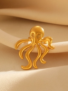 Detailed macro shot of an elegant gold octopus ring with curved tentacles on silk fabric