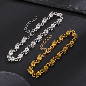 Dettaglio del bracciale a maglie con teschi stile punk e chiusura regolabile in argento e oro