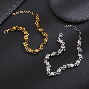 Dettaglio delle maglie a teschio gotico in oro e argento con chiusura regolabile