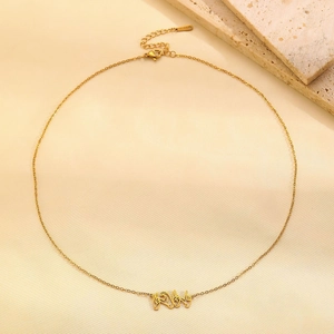 Detail der Goldkette mit Gebärdensprache-Anhänger und Karabinerverschluss auf hellem Stoff