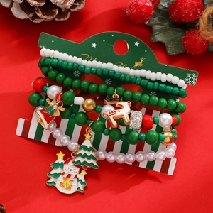 Dettaglio del set di braccialetti natalizi con ciondoli pupazzo di neve e renna su carta