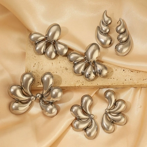 Silver liquid metal floral earrings and teardrop studs for parties on satin backdrop