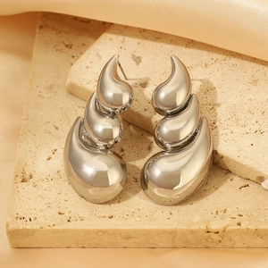 Macro shot of silver tiered waterdrop earrings with a high-polished mirror finish