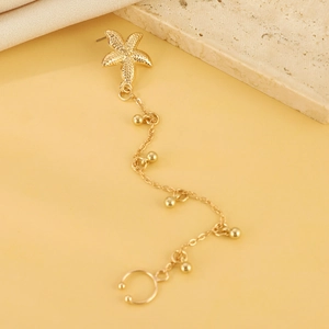 Dettaglio orecchino a stella marina dorato con catena di perline e ear cuff integrato