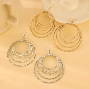 Detail of gold and silver layered hoop earrings featuring textured rope design on fish hooks