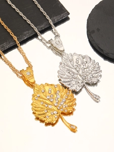 Primer plano detallado de colgantes de hoja en oro y plata con brillantes strass