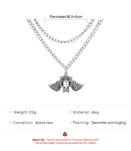 Macro view of silver alloy bat pendant with spider web texture on a double chain necklace