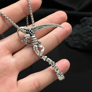 Close-up of retro silver reaper skull pendant with scythe on a metal chain