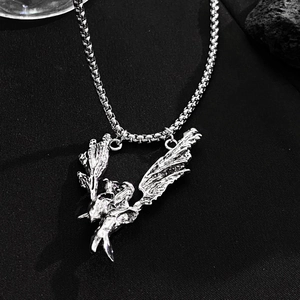 Close-up of vintage silver gothic pendant with asymmetric angel wings and box chain
