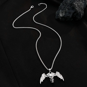 Gothic skull necklace with bat wings and motor engine pendant on black lava rocks