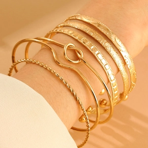 Detailed close-up of six gold-plated alloy bracelets featuring sun and moon motifs