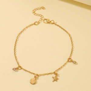 Detail von Gold-Seestern und Muschel-Anhängern an verstellbarer Strass-Fußkette