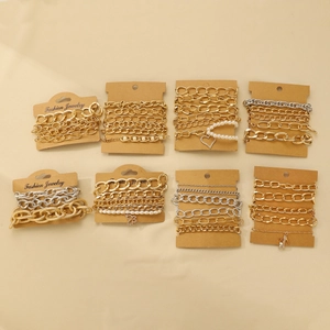 Detail of 8 sets gold and silver alloy knotted bracelet stacks with heart charms