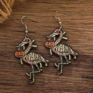 Close-up of Halloween wooden flamingo earrings featuring mummy bandages and pumpkin lantern