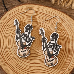 Detail shot of gothic skull playing guitar wooden earrings on a natural wood background