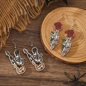 Gothic Halloween earrings featuring skeleton musician and rose design on wood texture