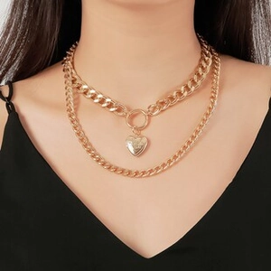 Nahaufnahme der zweilagigen goldenen Panzerkette mit Herzanhänger am Model